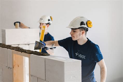 statybininkas tinkuoja sieną