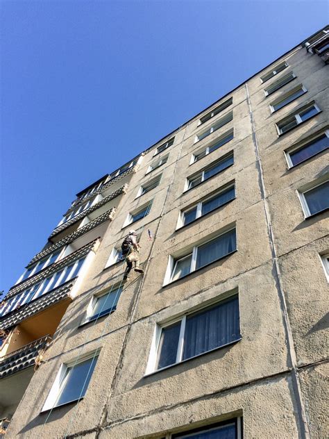 statybininkai dažantys namo fasadą