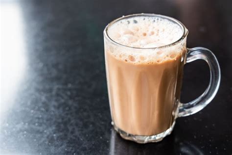 Indelis su pienu ir jogurto stiklinė, šalia dubenėlis su sūriu ir žuvies gabalėliais