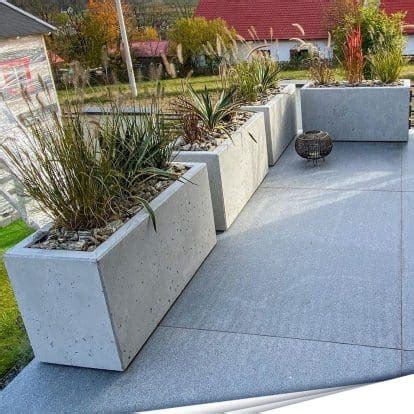 Betoniniai vazonai sodo aplinkoje