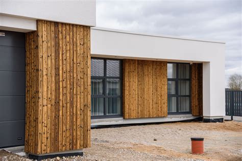 Medinio namo fasadas su vertikaliomis dailylentėmis