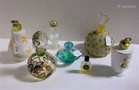 Rankomis laikomi kvepalų buteliukai su medžio elementais