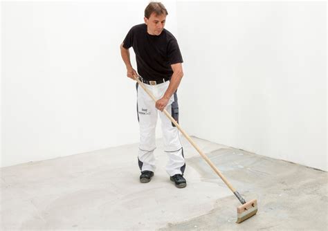 statybininkas lygina sieną prieš plytelių klijavimą