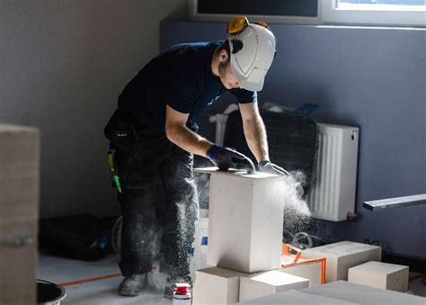 Statybininkas naudoja elektrinį polistirolo pjaustytuvą