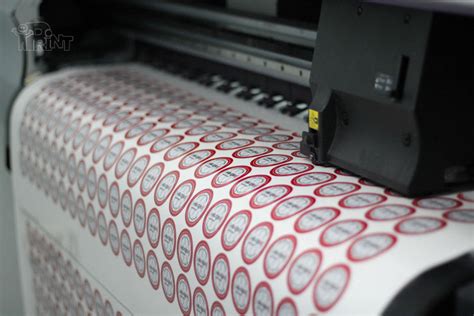 Darbuotojai klijuoja lipdukus ant produkcijos