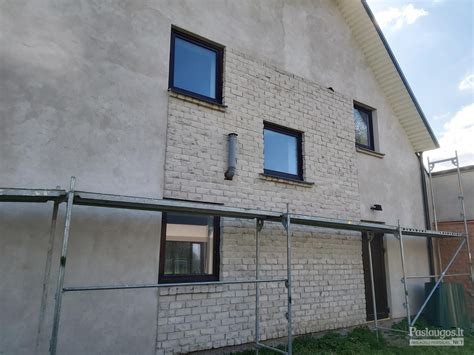 Šiltinimo darbų komanda montuoja fasado plokštes