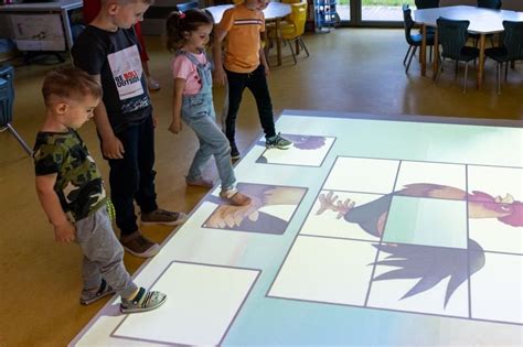 Interaktyvios grindys ant grindų projektuoja spalvingą žaidimų paviršių
