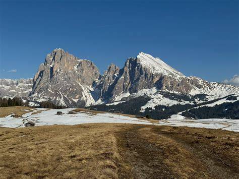 Dolomitų kraštovaizdai su kalnų viršūnėmis ir veja